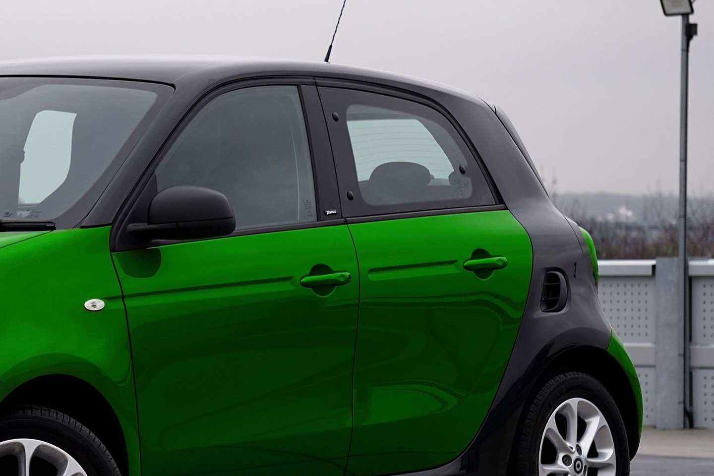 Grüner Kleinwagen in Seitenansicht auf einem Parkdeck