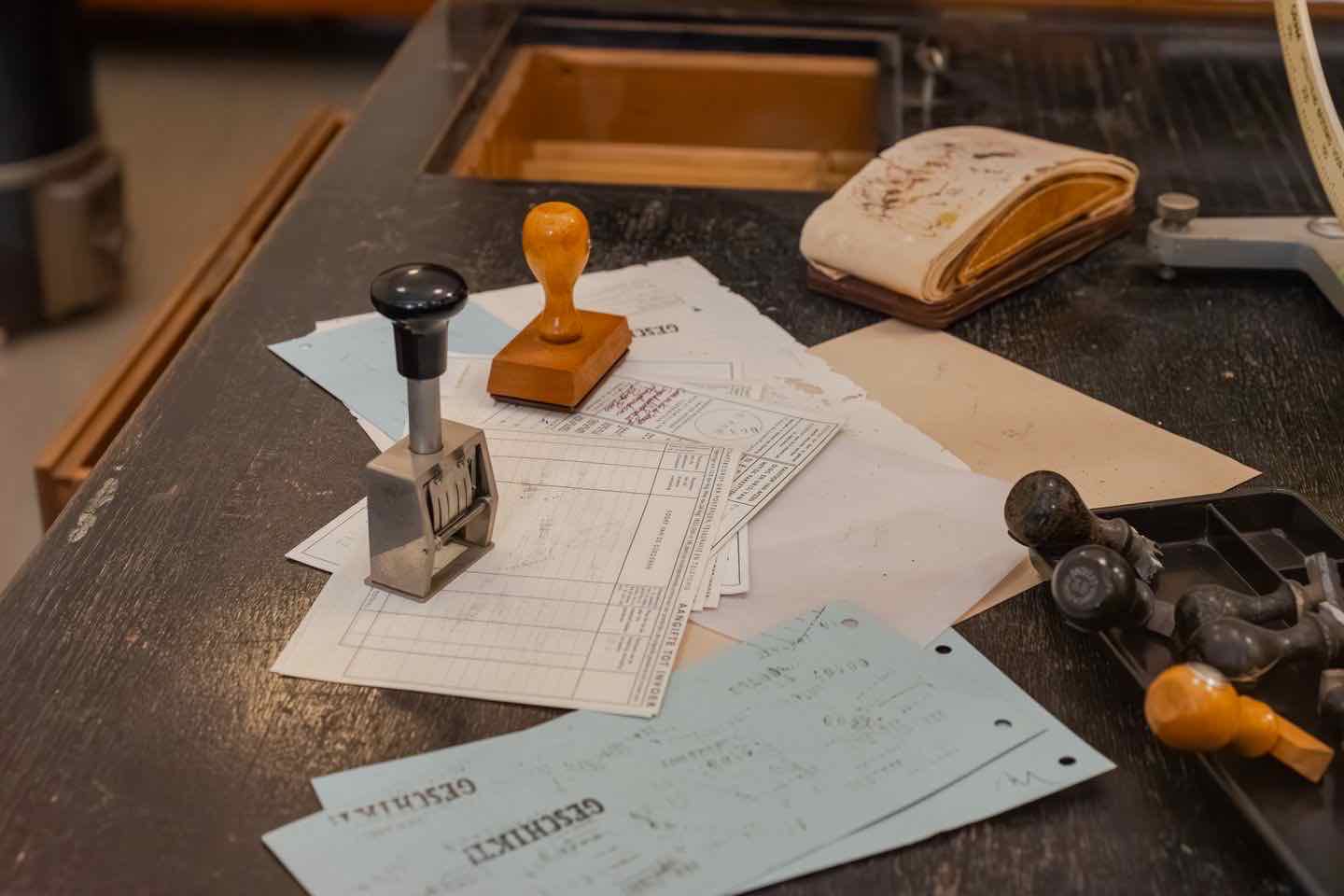 Stempel und gestempelte Formulare auf einem dunklen Arbeitstisch