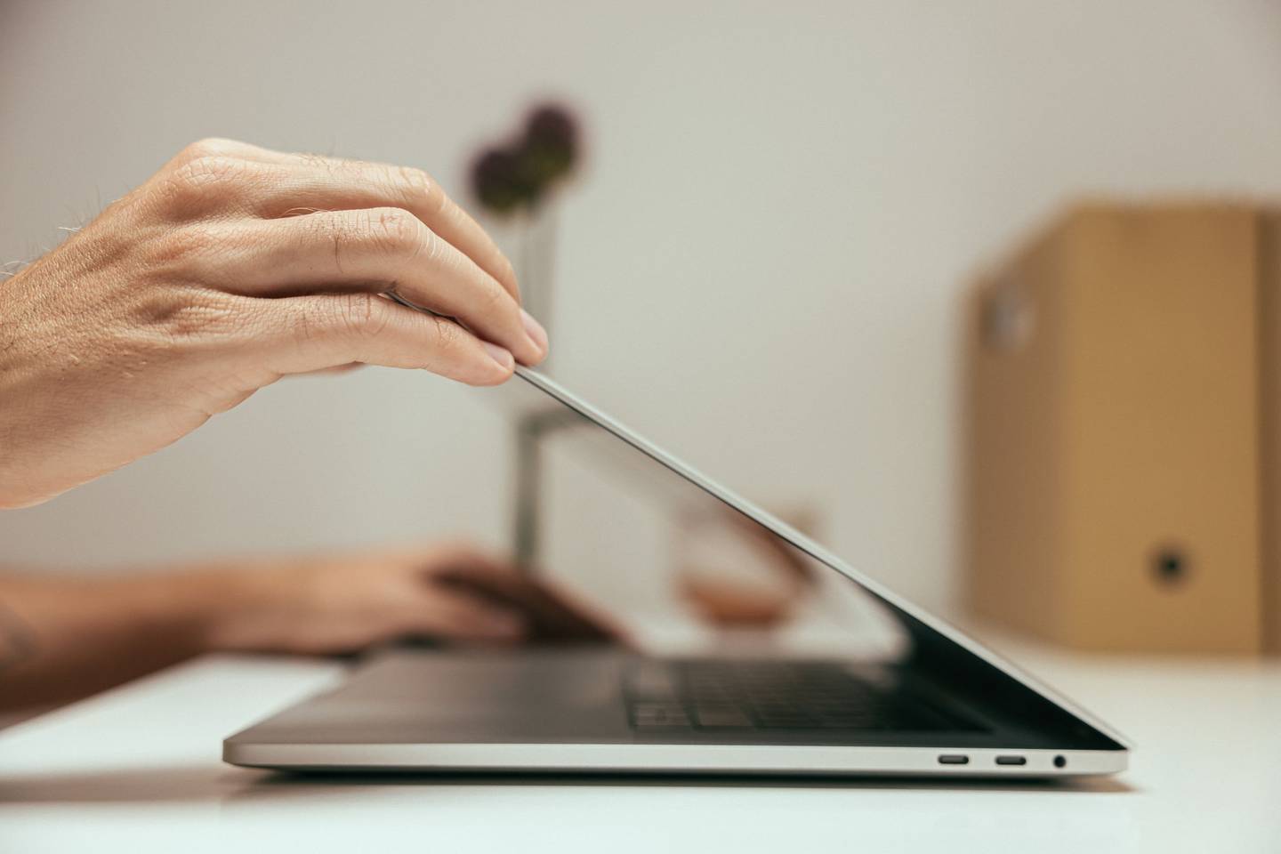 Eine Hand klappt einen Laptop zu