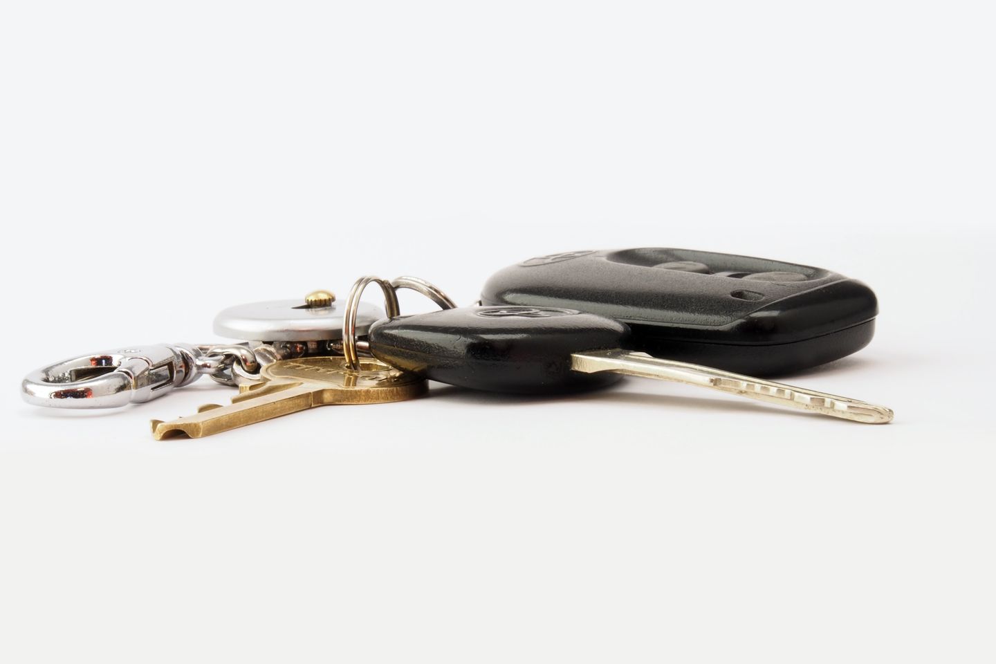 Autoschlüssel mit Funkfernbedienung und Schlüsselbund auf weißem Untergrund