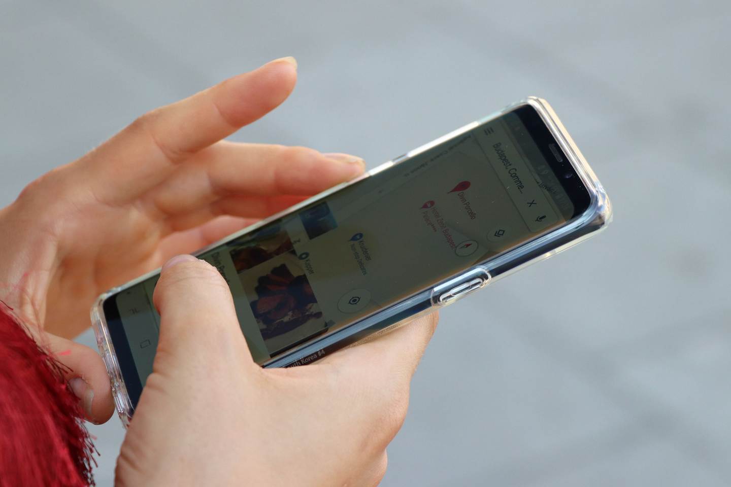 Zwei Hände halten ein Smartphone mit geöffneter Kartenansicht