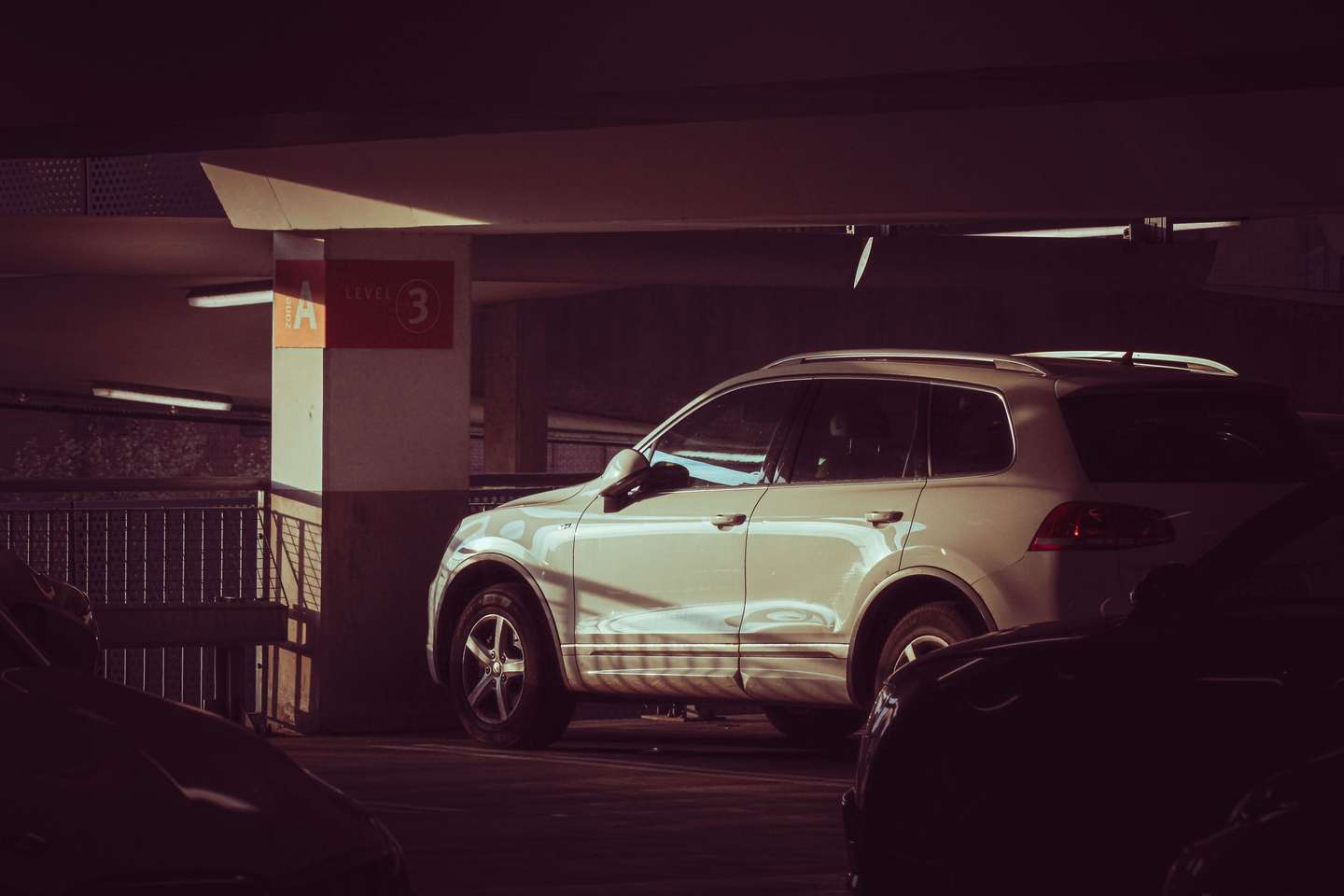 Heller Geländewagen steht allein in einem Parkhaus
