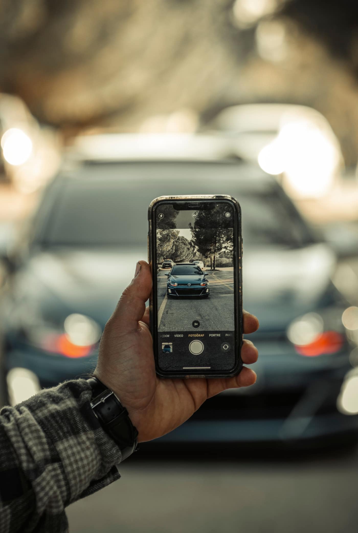 Verkäufer fotografiert sein Fahrzeug mit dem Smartphone für das Inserat