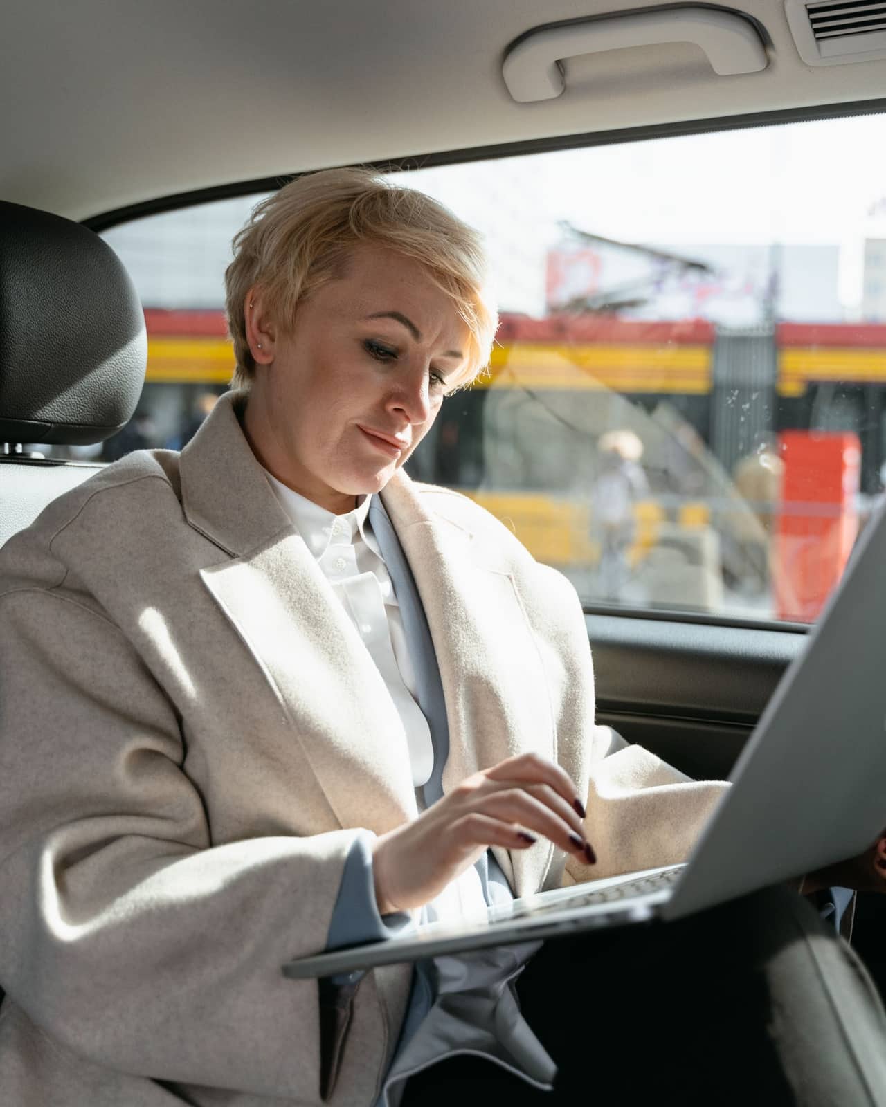 Frau liest den fertigen Inserat-Report am Laptop im Auto